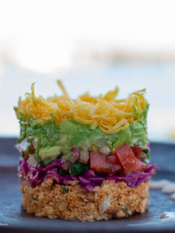 Baja Fish Taco Dip plated on a wood plate bayou in the background