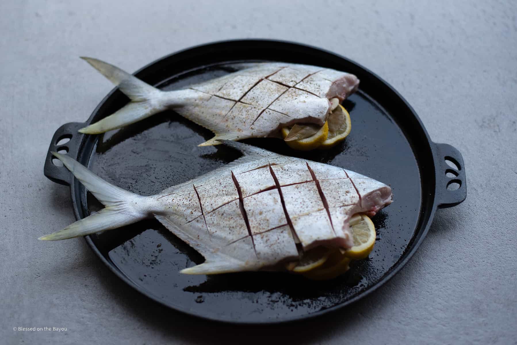 Pompano head removed stuffed with lemon garlic and bay leaf rubbed with olive oil and salt and pepper