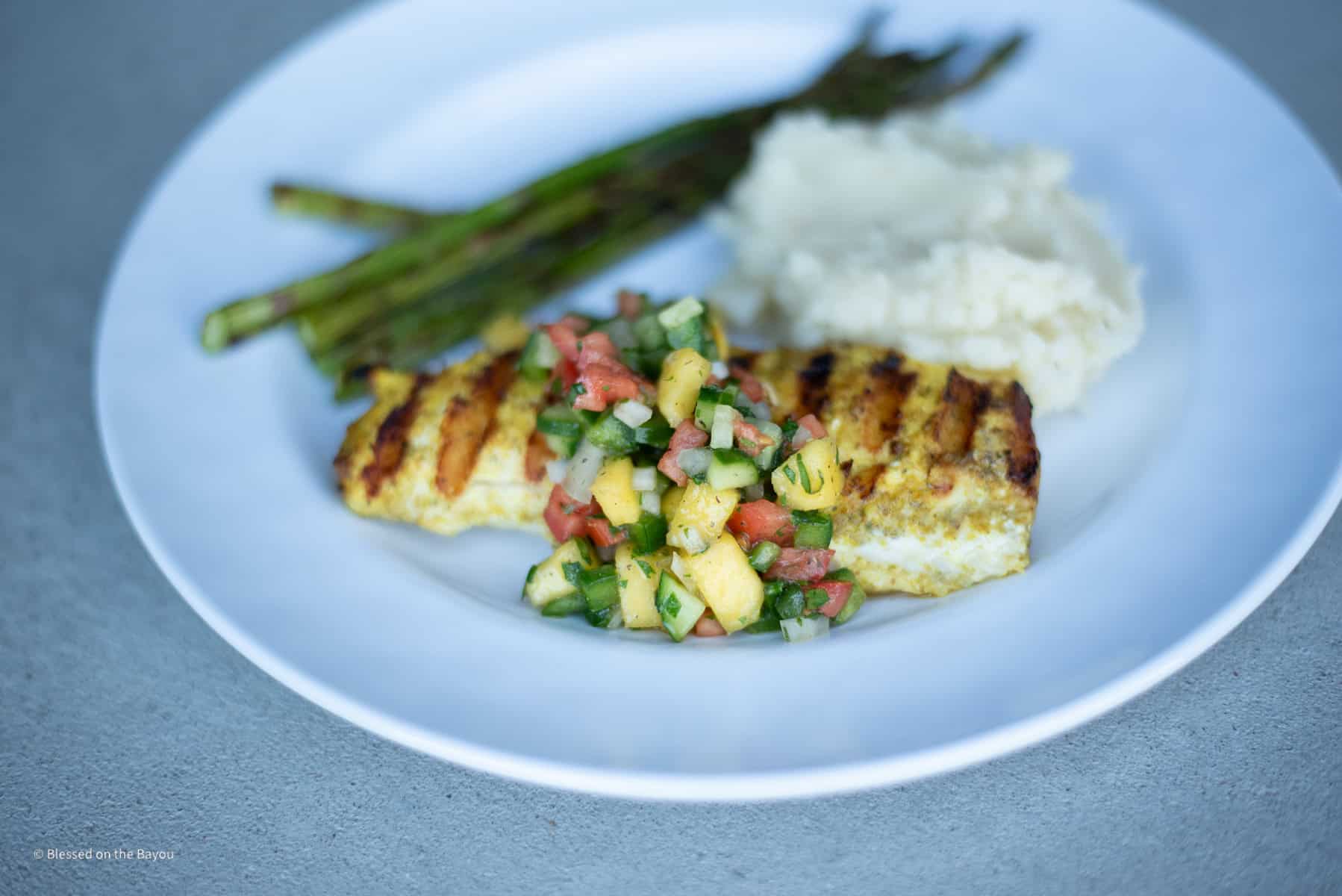 Grilled Wahoo with Mango Salsa Plated with Mashed Potatoes and Asparagus