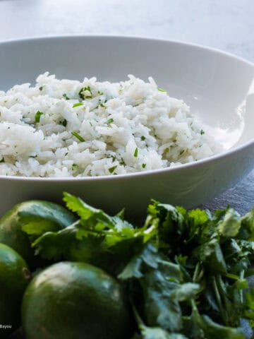 cilantro lime rice in a bowl with limes and cilantro