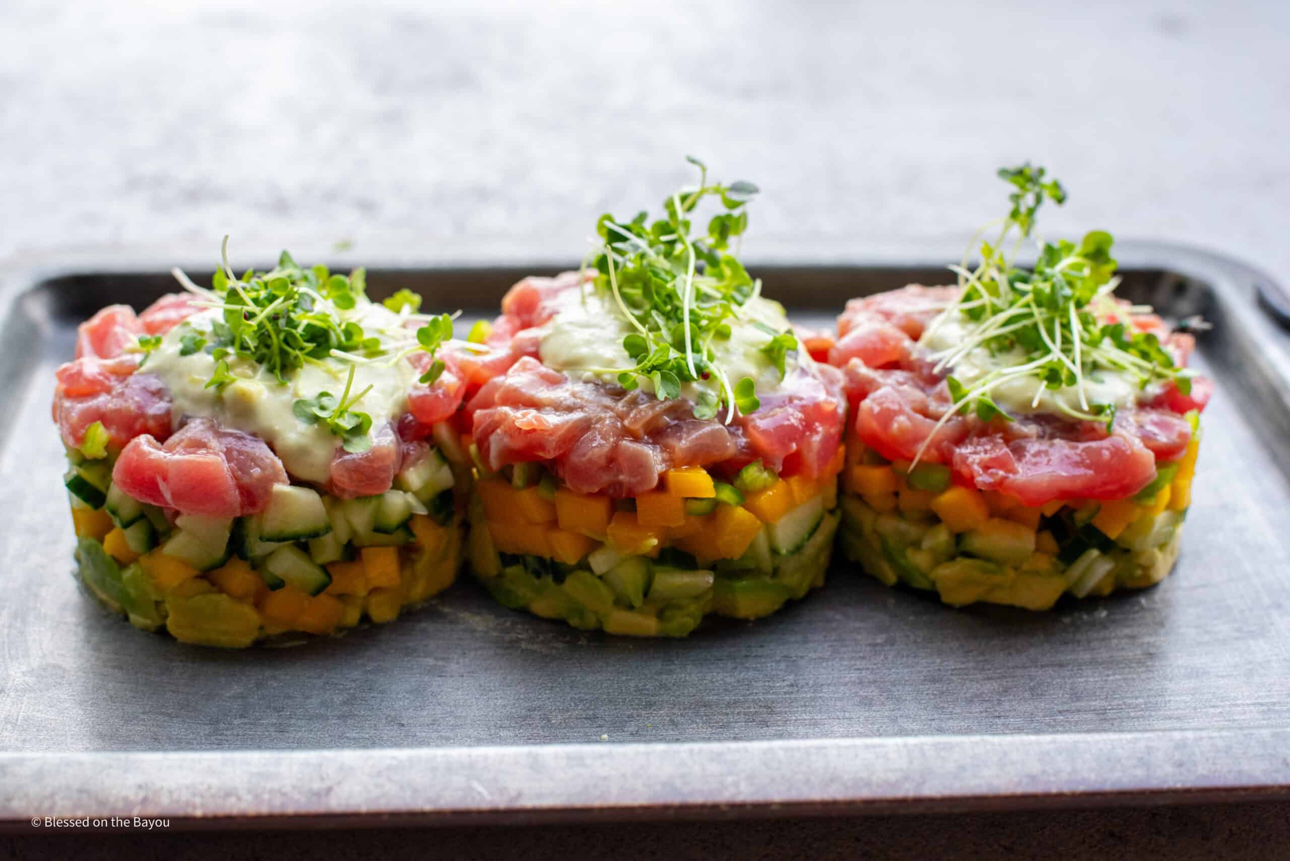 Tuna tartare stack plated with purple mustard sprouts