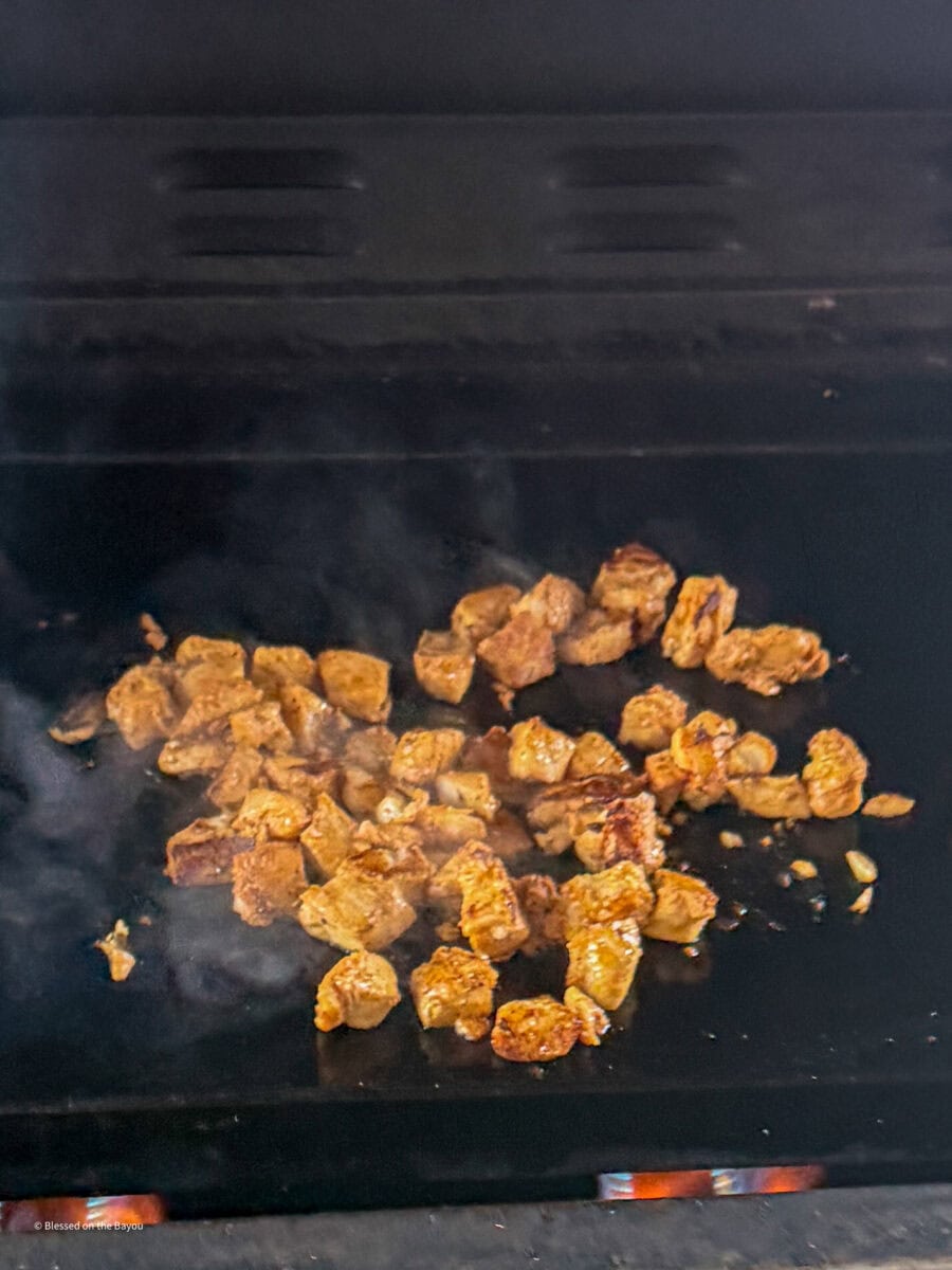 white cajun seasoned fish on the griddle